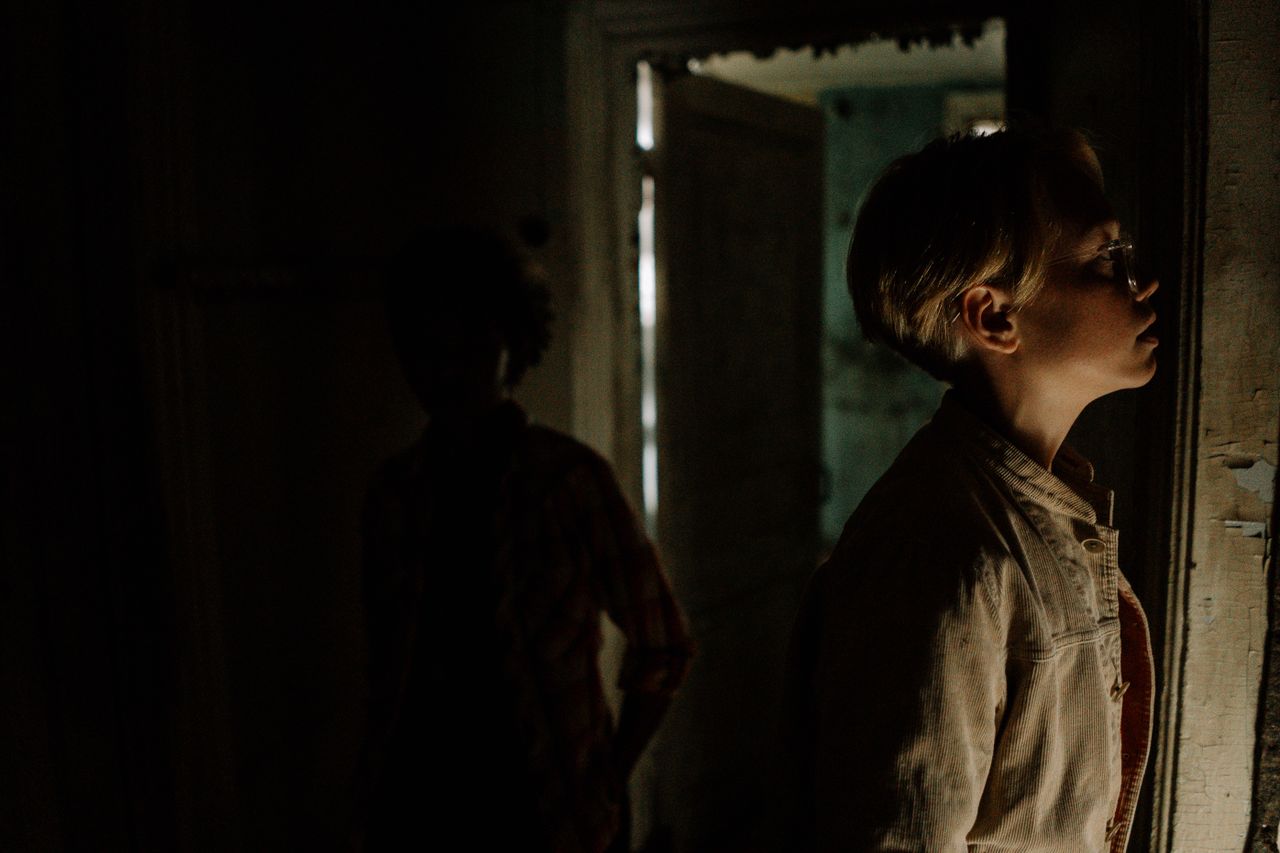 Mysterious and eerie atmosphere in a dimly lit abandoned room with shadowy figures.